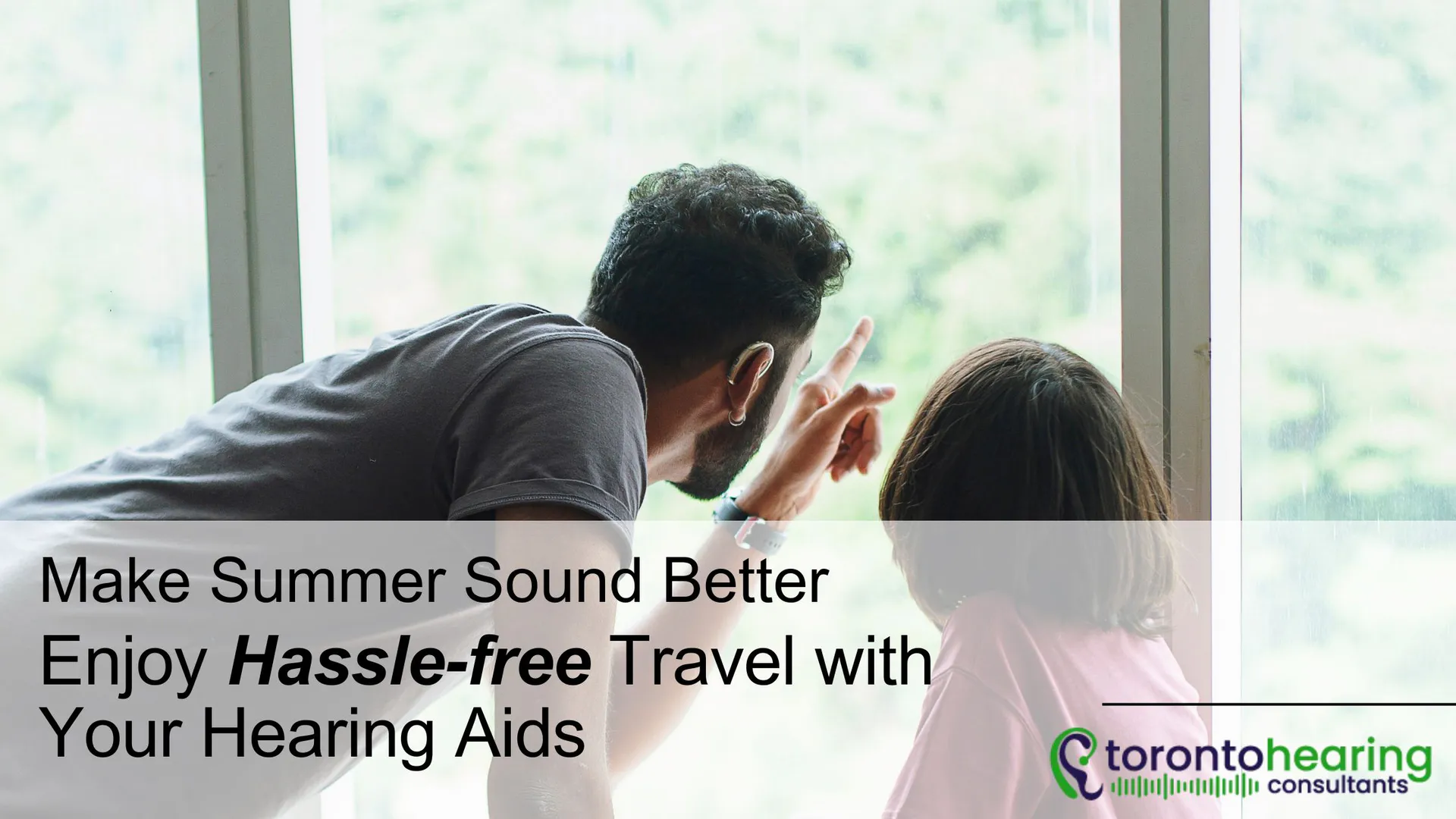 Father pointing outside a window with daughter, promoting hassle-free summer travel tips for hearing aid users – Toronto Hearing Consultants.