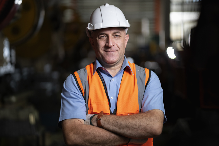 Male senior engineer standing with his arms crossed confidently.
