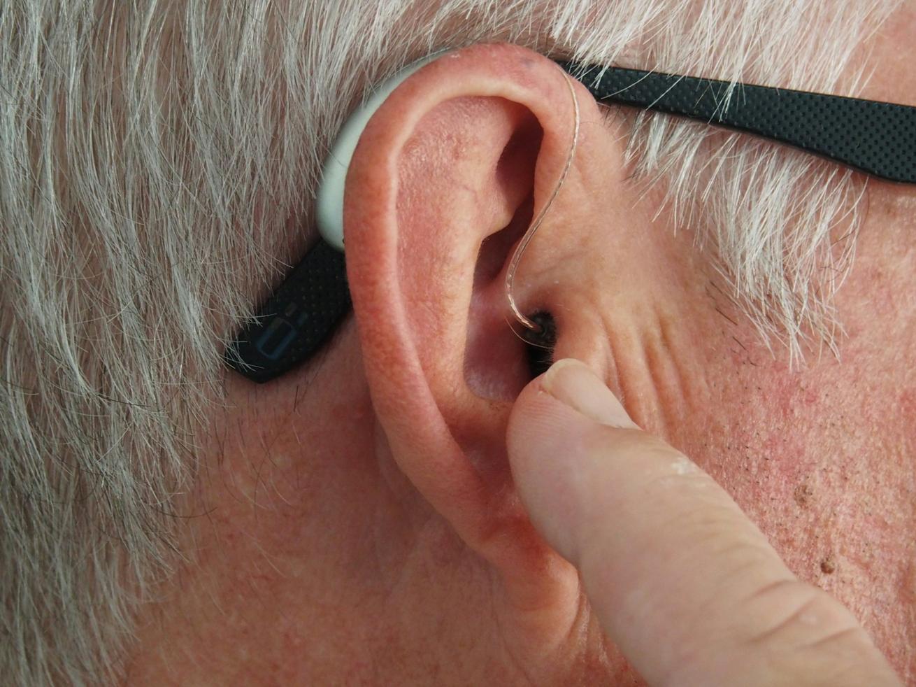 A man wearing a small, discreet hearing aid