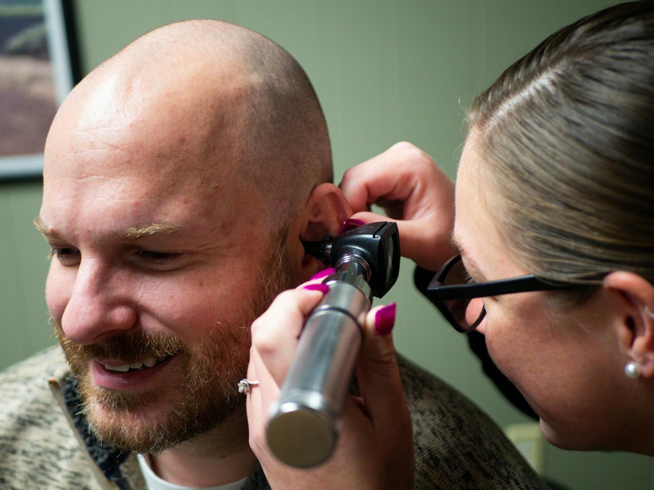 An audiologist tests a man’s hearing